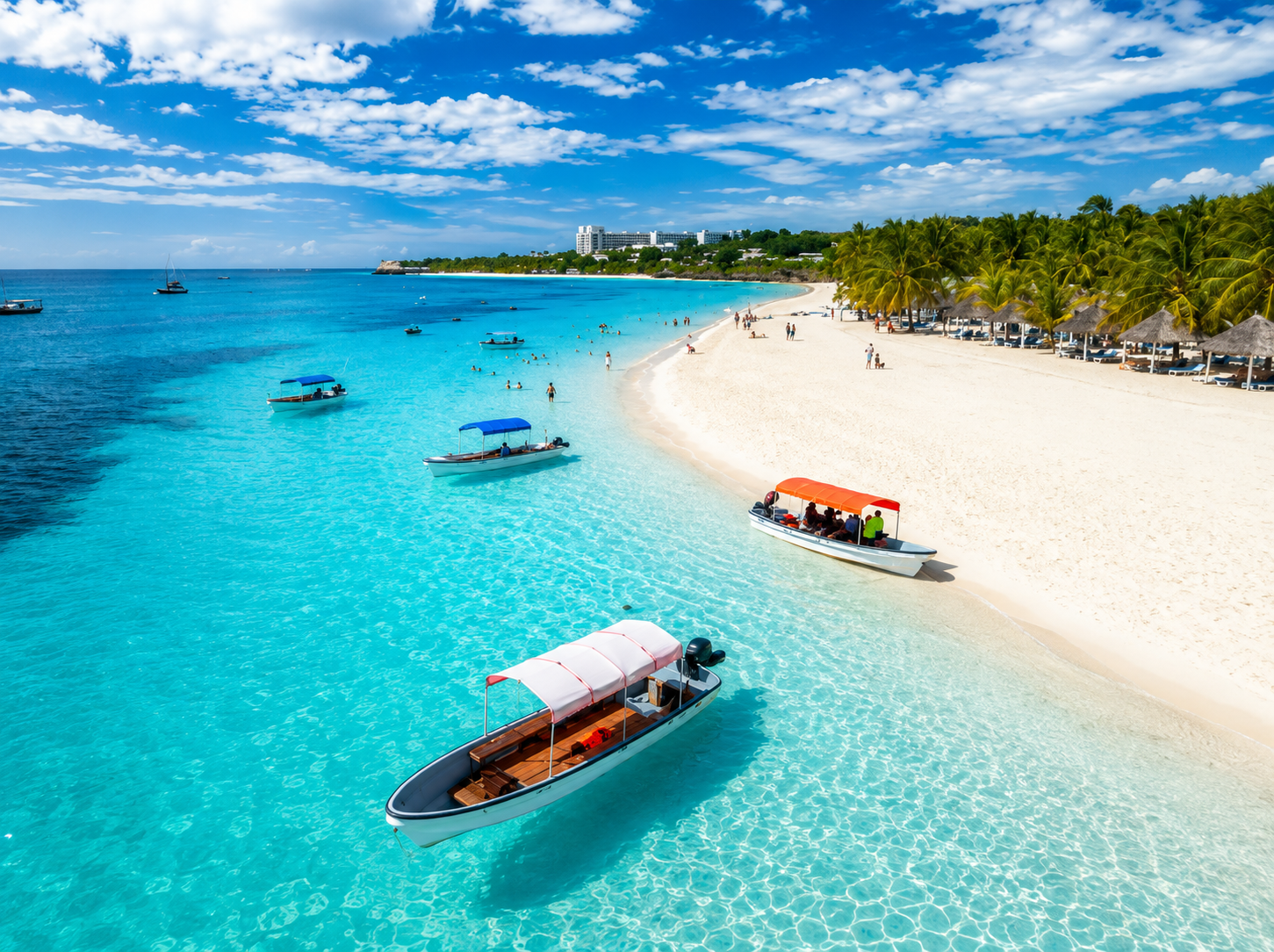 Turquoise island shoreline with boats and white sand beach